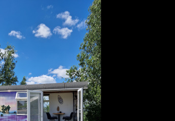 Tiny Wagon Lodge bei Marina Parcs Almere in den Niederlanden vor blauem Himmel mit Wolken.