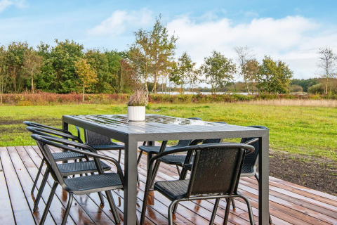 Buiten eettafel met zes stoelen op houten terras bij 8-persoons vakantiehuis in Ansager, met uitzicht.