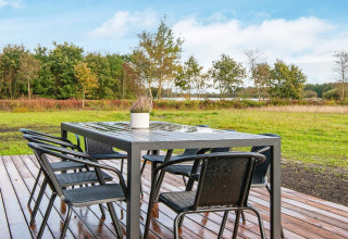 Buiten eettafel met zes stoelen op houten terras bij 8-persoons vakantiehuis in Ansager, met uitzicht.