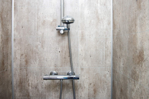 Ducha moderna con grifería cromada y azulejos claros en casa de vacaciones para 8 personas en Ansager, Dinamarca.