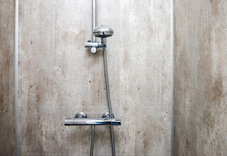 Ducha moderna con grifería cromada y azulejos claros en casa de vacaciones para 8 personas en Ansager, Dinamarca.