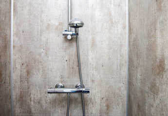 Modern shower with chrome fixtures and light tiles inside 8 person holiday home in Ansager, Denmark.