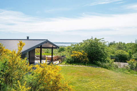 Modern vakantiehuis in Ebeltoft, Denemarken, met overdekt terras, tuin en zeezicht.