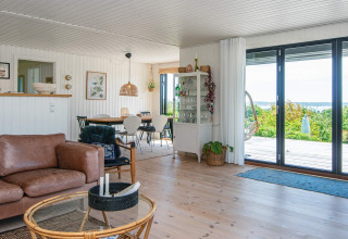 Salón de casa vacacional en Ebeltoft, Dinamarca, con decoración moderna, ventanales y vista natural.