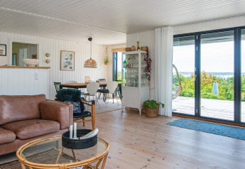 Woonkamer in een vakantiehuis in Ebeltoft, Denemarken, modern ingericht met grote ramen en uitzicht.