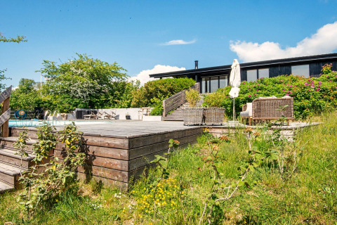 Terrasse en bois ensoleillée avec piscine et jardin d'une maison de vacances 8 personnes à Ebeltoft, Danemark