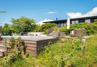 Terrasse en bois ensoleillée avec piscine et jardin d'une maison de vacances 8 personnes à Ebeltoft, Danemark