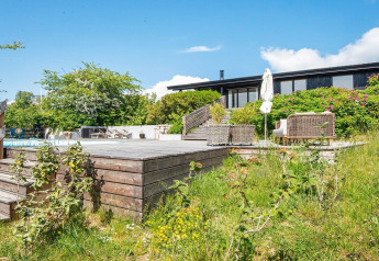 Zonnig houten terras met zwembad en tuinmeubels bij 8-persoons vakantiehuis in Ebeltoft, Denemarken