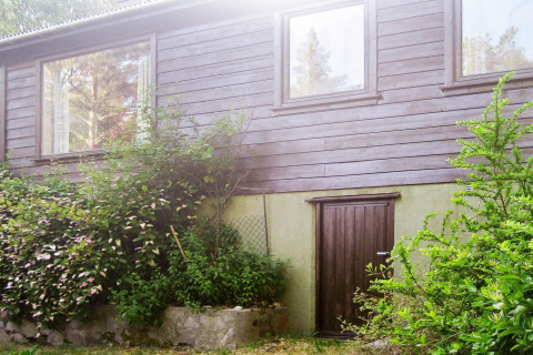 Außenansicht eines 4-Personen-Ferienhauses in Reksteren, Dänemark, mit Holzfassade und viel Grün.