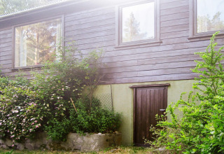 Buitenzicht op het 4-persoons vakantiehuis in Reksteren, Denemarken, met houten gevel en groen.