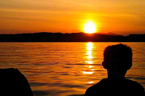 Sagoma di una persona al tramonto sull'acqua presso la casa vacanze per 4 persone a Reksteren, Danimarca.