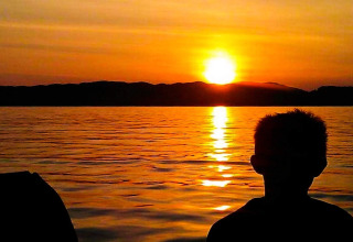 Sagoma di una persona al tramonto sull'acqua presso la casa vacanze per 4 persone a Reksteren, Danimarca.