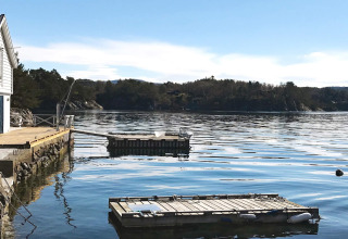 Uitzicht vanaf lodge in Reksteren, Denemarken, met houten steiger en drijvende pontons op het water.