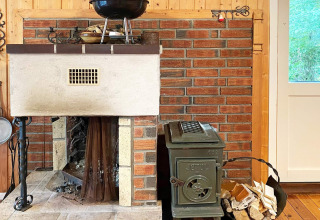 Gezellige hoek met open haard en houtkachel in een houten vakantiehuis in Reksteren, Denemarken, met hout.