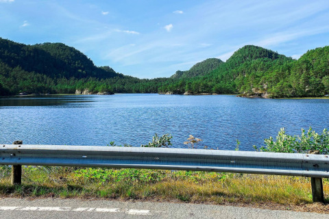 Blick auf einen See und bewaldete Hügel von der Straße am 4-Personen-Ferienhaus in Reksteren, Dänemark.