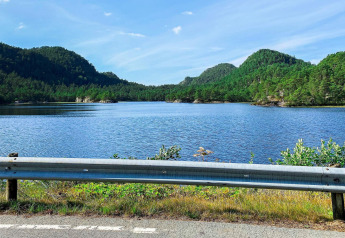 Vista di un lago e colline verdi dalla strada presso la casa vacanze per 4 persone a Reksteren, Danimarca.