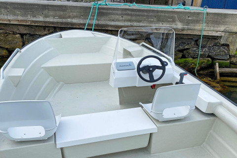 Stuurstand en zitplaatsen van een kleine boot bij de steiger, bij ‘4 persoons vakantiehuis in Reksteren’, Denemarken.