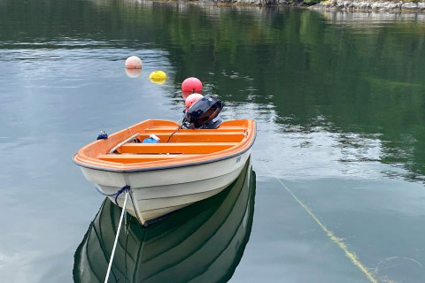 Kleine oranje-witte roeiboot aangemeerd bij een 4-persoons vakantiehuis in Reksteren, Denemarken.
