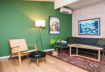 Sala de estar en casa de vacaciones para 5 personas en Ans By, Dinamarca, con pared verde y muebles modernos.