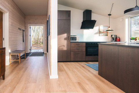 Cocina moderna y pasillo con suelo de madera en casa de vacaciones para 5 personas en Ans By, Dinamarca.