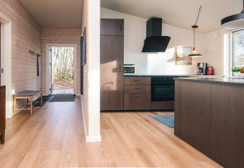 Cocina moderna y pasillo con suelo de madera en casa de vacaciones para 5 personas en Ans By, Dinamarca.