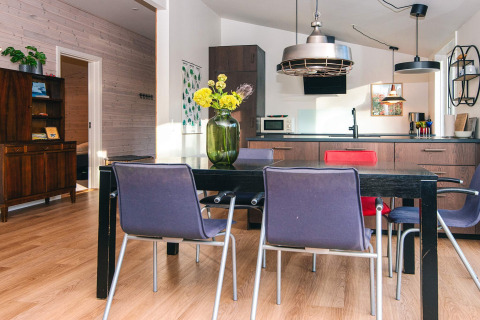 Moderne eet- en keukenruimte in een vakantiehuis in Ans By, Denemarken, met planten en gekleurde stoelen.
