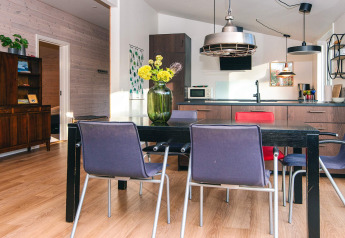Stylish dining and kitchen space in a holiday home in Ans By, Denmark, with plants and colorful chairs.