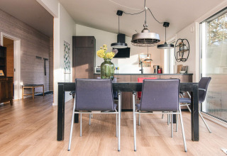 Salle à manger et cuisine moderne d'une maison de vacances à Ans By, Danemark, avec parquet clair.