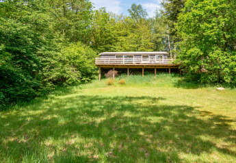 Vue d'une maison de vacances pour 5 personnes à Ans By, Danemark, entourée de verdure et d'arbres.