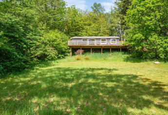 Vue d'une maison de vacances pour 5 personnes à Ans By, Danemark, entourée de verdure et d'arbres.