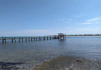 Foto di un molo e una barca su acqua calma vicino a Hadsund, Danimarca, vista dalla riva.