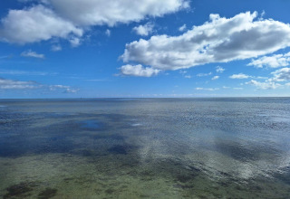 Vue sur la mer claire et le ciel bleu avec des nuages depuis la maison de vacances 10 personnes à Hadsund, Danemark.
