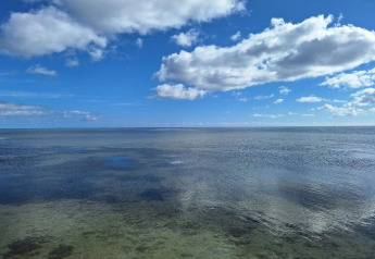Uitzicht op de heldere zee en blauwe lucht met wolken bij het 10-persoons vakantiehuis in Hadsund, Denemarken.