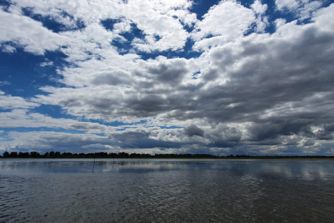 Cielo nublado reflejado en aguas tranquilas junto a la casa de vacaciones para 10 personas en Hadsund, Dinamarca.