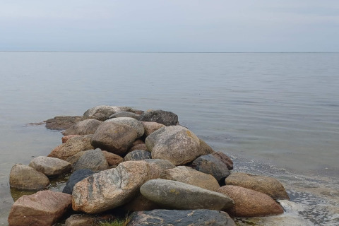 Stapel stenen langs het rustige water nabij de lodge ‘10-persoons vakantiehuis in Hadsund’ in Denemarken.