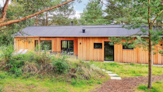 Træhytte i en grøn skov ved Ålbæk, ideel til 8 personer, rolige omgivelser og moderne design.