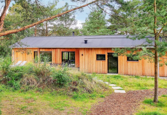 Vakantiehuis voor 8 personen in Ålbæk met houten gevel, omringd door groen en bomen in de natuur.