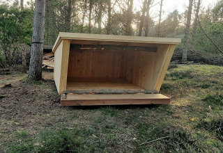 Rifugio in legno nel bosco vicino a casa vacanze per 8 persone ad Ålbæk, Danimarca, tra gli alberi.