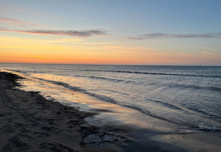 Coucher de soleil sur la plage à Ålbæk, Danemark, vu depuis maison de vacances pour 8 personnes. Vagues douces.