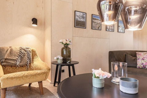 Knusse zithoek in 8-persoons vakantiehuis in Ålbæk, Denemarken, met moderne meubels en wandfoto's.