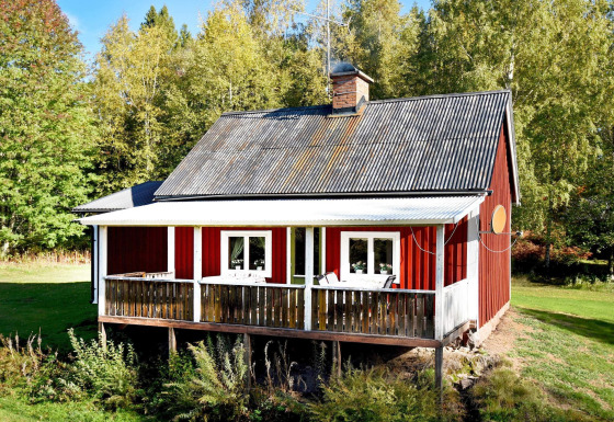 Red holiday chalet in Sunnemo with large veranda, surrounded by greenery, suitable for 7 people.