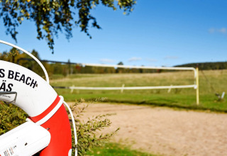 Redningskrans ved sandvolleyballbane på 7 personers feriehus i Sunnemo, Sverige, på en solrig dag.
