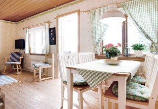 Bright dining area in a 7-person chalet in Sunnemo, Sweden, featuring checkered curtains and wooden furniture.