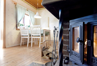 Salon chaleureux du chalet '7 person holiday home in Sunnemo' en Suède, avec poêle et coin repas.
