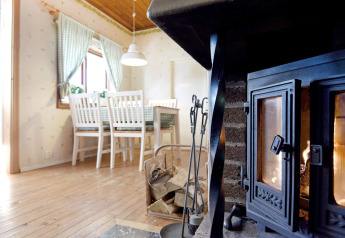 Cozy living area in '7 person holiday home in Sunnemo' chalet, Sweden, with fireplace and dining table.