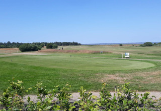 Vista del campo de golf desde la cabaña 'Seaside Escape in Ho Bay' en Dinamarca en un día soleado.