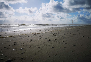 Beach and sea view at Ho Bay, Denmark, with clouds and sunlight near the Seaside Escape cabin.