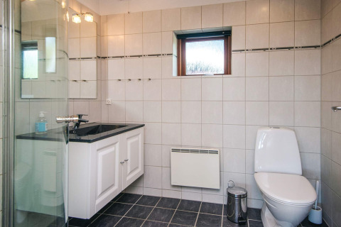 Bagno moderno al Seaside Escape in Ho Bay, Danimarca, con WC, lavandino e box doccia in vetro.