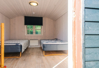 To enkeltsenge i et lyst træindrettet værelse i kabinen 'Seaside Escape in Ho Bay', Danmark.