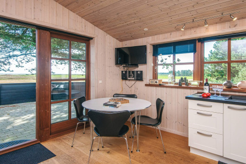 Bright dining area and kitchen inside 'Seaside Escape in Ho Bay' cabin with scenic view, Denmark.